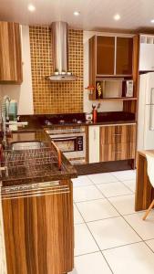 cocina con armarios de madera y encimera en Casa grande em bairro tranquilo en Pato Branco