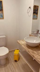 a bathroom with a white toilet and a sink at Casa grande em bairro tranquilo in Pato Branco