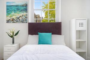 倫敦的住宿－Large 2 Bed Apartment London Camberwell Champion Park Denmark Hill - Great For Long Stays，卧室配有白色床和蓝色枕头