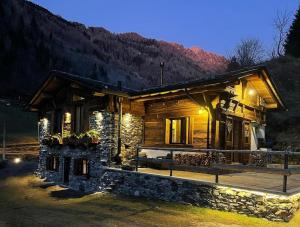 a log cabin with a porch at night at Bed and Breakfast Campo Base in Carona