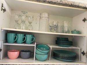 a shelf filled with plates and glasses and dishes at Departamento Los Delfines in Iquique