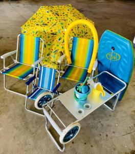 ein Spielset mit zwei Stühlen und einem Regenschirm in der Unterkunft Um passo do mar in Guarapari