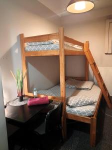 a room with a bunk bed with a desk at GO Hostel Rewolucji in Łódź