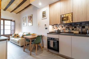 a kitchen and living room with a table and a couch at Caleffa Triunfo 1 in Granada