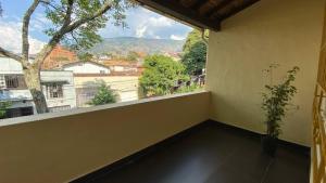 a balcony with a window with a view of a city at Apartaestudios Prado Station in Medellín