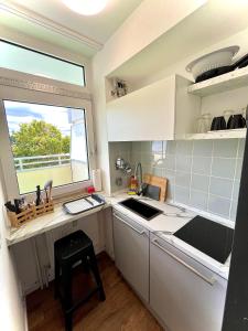 een kleine keuken met een wastafel en een raam bij RentApart`s Nürnberg City Smart in Neurenberg