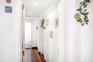 a hallway with white walls and a clock on the wall at Santos Mattos Guesthouse & Apartments by Lisbon with Sintra in Amadora