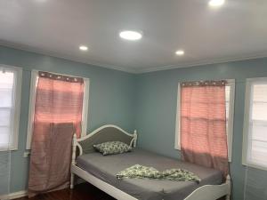 a bed in a room with blue walls and windows at Vacation home rental in Georgetown