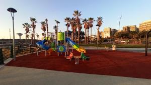 a playground with slides and palm trees in a park at CasaTua in Catania
