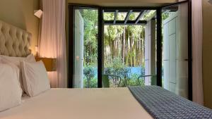 Schlafzimmer mit einem Bett und einer Glasschiebetür in der Unterkunft Jardim da Batalha Boutique Hotel by Shiadu in Porto
