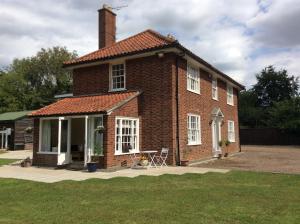 una casa de ladrillo con una mesa delante en Beightons Bed and Breakfast, en Bury Saint Edmunds