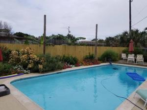 a large blue swimming pool in a yard at The Seahorse Apt - Lakeside and Close to the Beach in Galveston