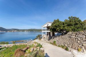 a house on a hill next to a stone wall at Apartment Nives in Vis