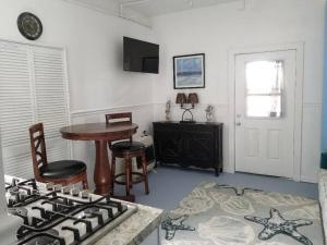a kitchen with a stove and a table and a table at The Seahorse Apt - Lakeside and Close to the Beach in Galveston