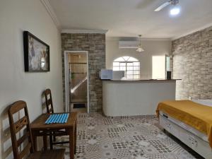 a room with a bed and a table and a kitchen at Encantu's Flats in Itatiaia