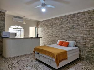 um quarto com uma cama e uma parede de tijolos em Encantu's Flats em Itatiaia