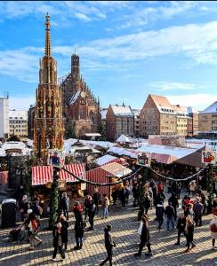 a group of people walking around a christmas market at RentApart`s Nürnberg City Smart in Nuremberg