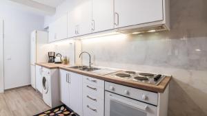 a white kitchen with a sink and a stove at Comfort Zone in Ioannina in Ioannina