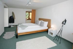 Bed & Breakfast Müllers Klostermühle في مونستيرتال: غرفة نوم بسرير وكاميرا على ثلاثي