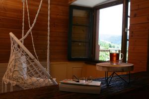 a room with a hammock and a book and a drink at Bed & Breakfast Müllers Klostermühle in Münstertal