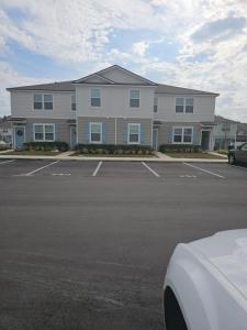 a large building with a parking lot in front of it at Orange Park Townhome Vacation Rental with Patio! in Orange Park