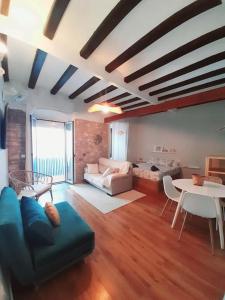 a living room with a couch and a table at Bonito estudio en el centro. Ideal parejas. in Palamós