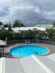 Una persona está en el agua en una piscina. en Duplex du Golfeur, en Saint-François