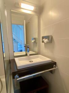 Un baño con un lavabo blanco y un espejo. en Duplex du Golfeur, en Saint-François