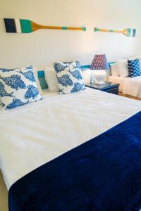 a bedroom with a bed with blue and white pillows at Sauipe Resorts Ala Mar - All Inclusive in Costa do Sauipe