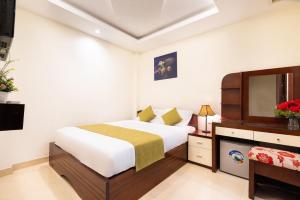 1 dormitorio con 1 cama y TV en Boutique hotel, en Ho Chi Minh