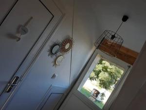 a door with two mirrors and a window next to it at la mansarde in La Cochère