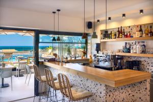 a bar in a restaurant with a view of the ocean at Calla Luxury Seafront Suites in Rethymno Town