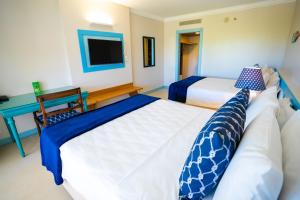 um quarto de hotel com duas camas e uma televisão em Sauipe Resorts Ala Mar - All Inclusive na Costa do Sauípe