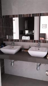 a bathroom with two sinks and a mirror at Casa Provenza Bucaramanga in Bucaramanga