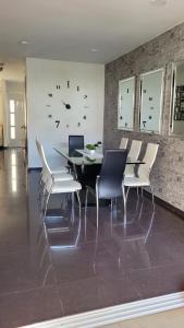 布卡拉曼加的住宿－Casa Provenza Bucaramanga，一间带桌子和白色椅子的用餐室