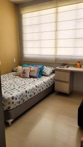 Casa Provenza Bucaramanga في بوكارامانغا: غرفة نوم مع سرير مع نافذة ومكتب