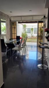 a dining room with a table and chairs and a pool at Casa Provenza Bucaramanga in Bucaramanga