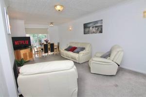 a living room with two white chairs and a table at 3Bed Gem Near Coventry Building Society Arena in Coventry