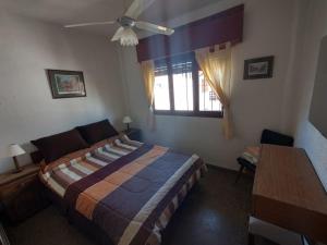 een slaapkamer met een bed, een raam en een tafel bij Departamento zona muelle frente al mar in Villa Gesell