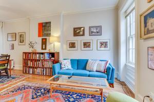 uma sala de estar com um sofá azul e uma mesa em MCM-Inspired Philadelphia Apartment Private Deck em Filadélfia
