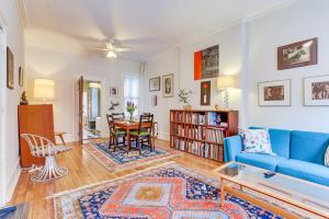 uma sala de estar com um sofá azul e uma mesa em MCM-Inspired Philadelphia Apartment Private Deck em Filadélfia