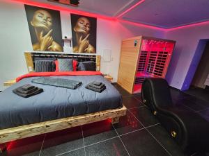 a bedroom with a large bed and a black chair at Magnifique Suite Spa Luxembourg in Differdange