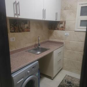 a kitchen with a sink and a washing machine at Hurghada Sea View Apartment in Hurghada