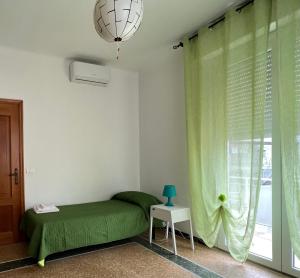 Villa al mare في سينِغاليا: غرفة نوم بسرير اخضر ونافذة
