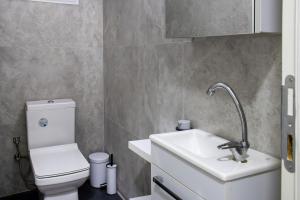 a bathroom with a white toilet and a sink at Mia apt. in İzmir
