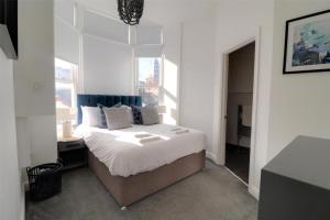 a bedroom with a large bed and a window at Sound of the Sea - Ilfracombe in Ilfracombe