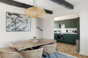 a kitchen with green cabinets and a wooden table and chairs at Luxury Stay at Oakmere Lodge in Oxton