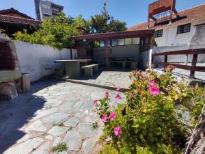 een patio met roze bloemen voor een gebouw bij Departamento zona muelle frente al mar in Villa Gesell