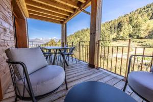 a balcony with tables and chairs and a view of the mountains at Résidence LES CRISTAUX - Duplex CRISTAUX C 764 in Bourg-Saint-Maurice