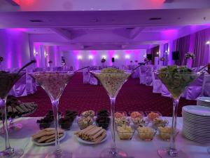 - une table avec des verres à vin dans une pièce dotée d'un éclairage violet dans l'établissement Mayberry Highway - Apartmani Medijapark, à Sveti Nikole